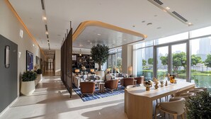 A modern hotel lobby with a central seating area, a reception desk, and large windows offering city views. - WYZ RENT|2BR Vida Dubai Mall Direct Mall Access (Dubai)