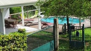 A covered outdoor seating area with a pool, surrounded by greenery. - Les terrasses de Maëlle II - Pretty villa with pool and sea view in Rivière-Salée (Rivière-Salée)