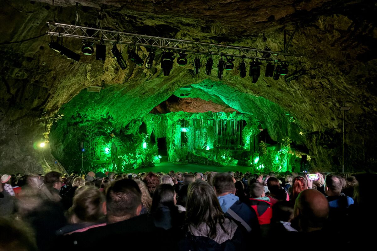 A cave with a stage and audience.