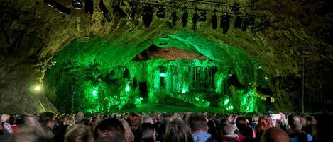 A cave with a stage and audience.