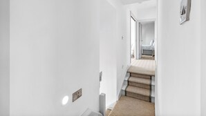 A modern, minimalist hallway with a carpeted staircase leading to a bedroom. - Beautiful 4-bedroom house with stunning sea views in the village of Guileen (Whitegate)