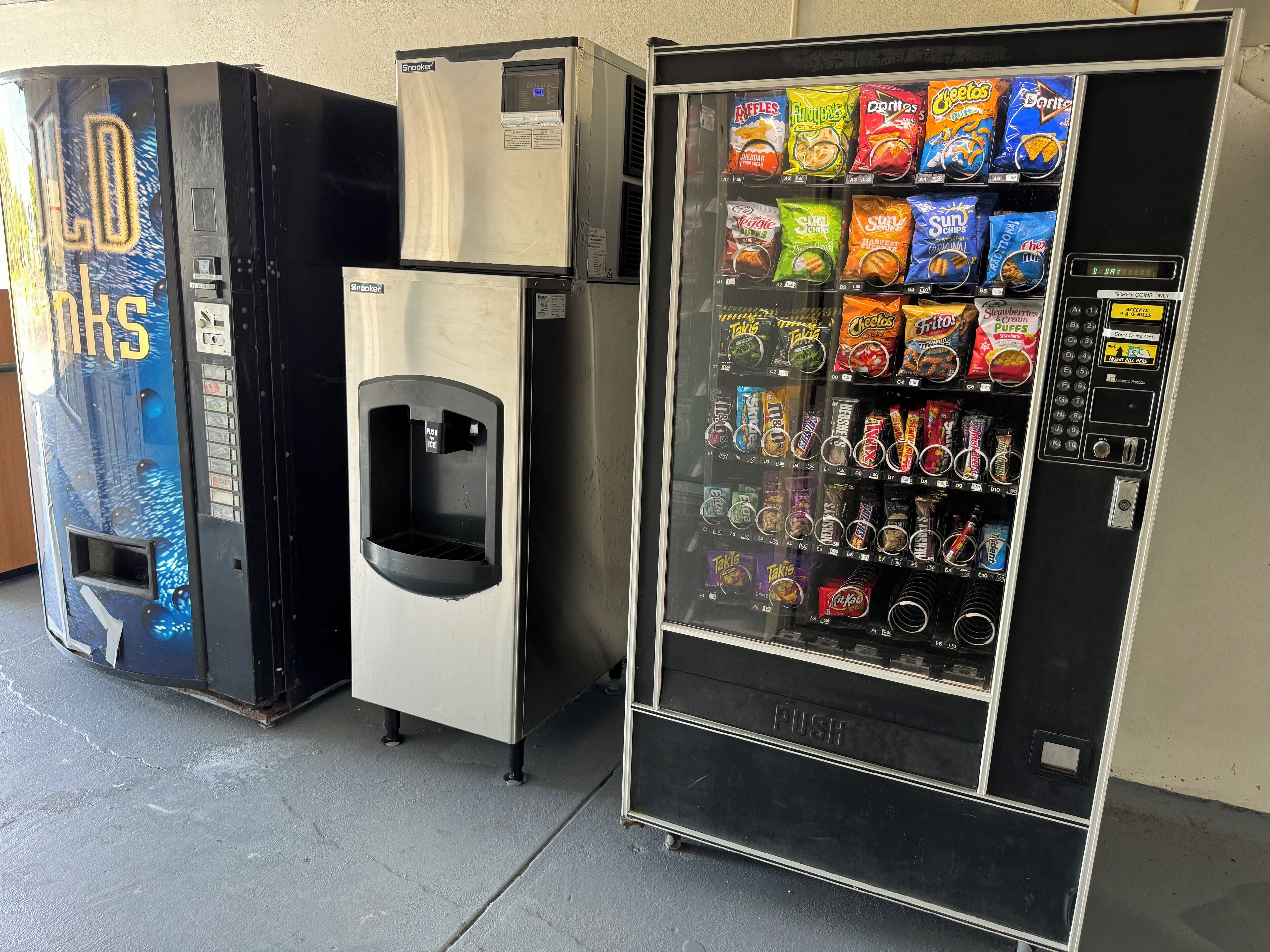 Máquina expendedora con diversas opciones de aperitivos y dispensador de agua.