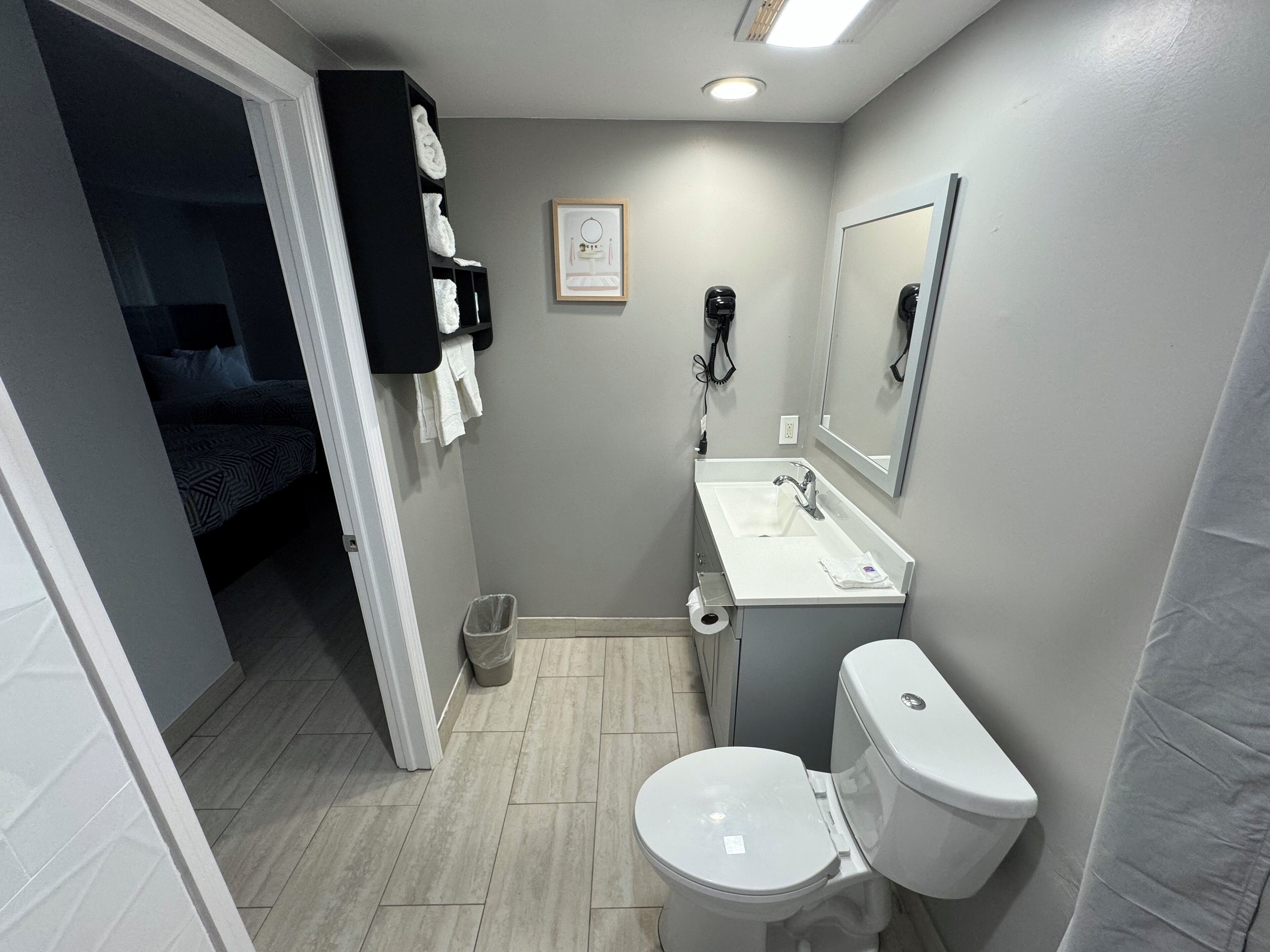 Un baño pequeño con inodoro, lavamanos y perchero para toallas.