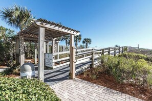 A wooden boardwalk leading to a gazebo with a sign indicating handicap ramp access at The Ramada Inn.