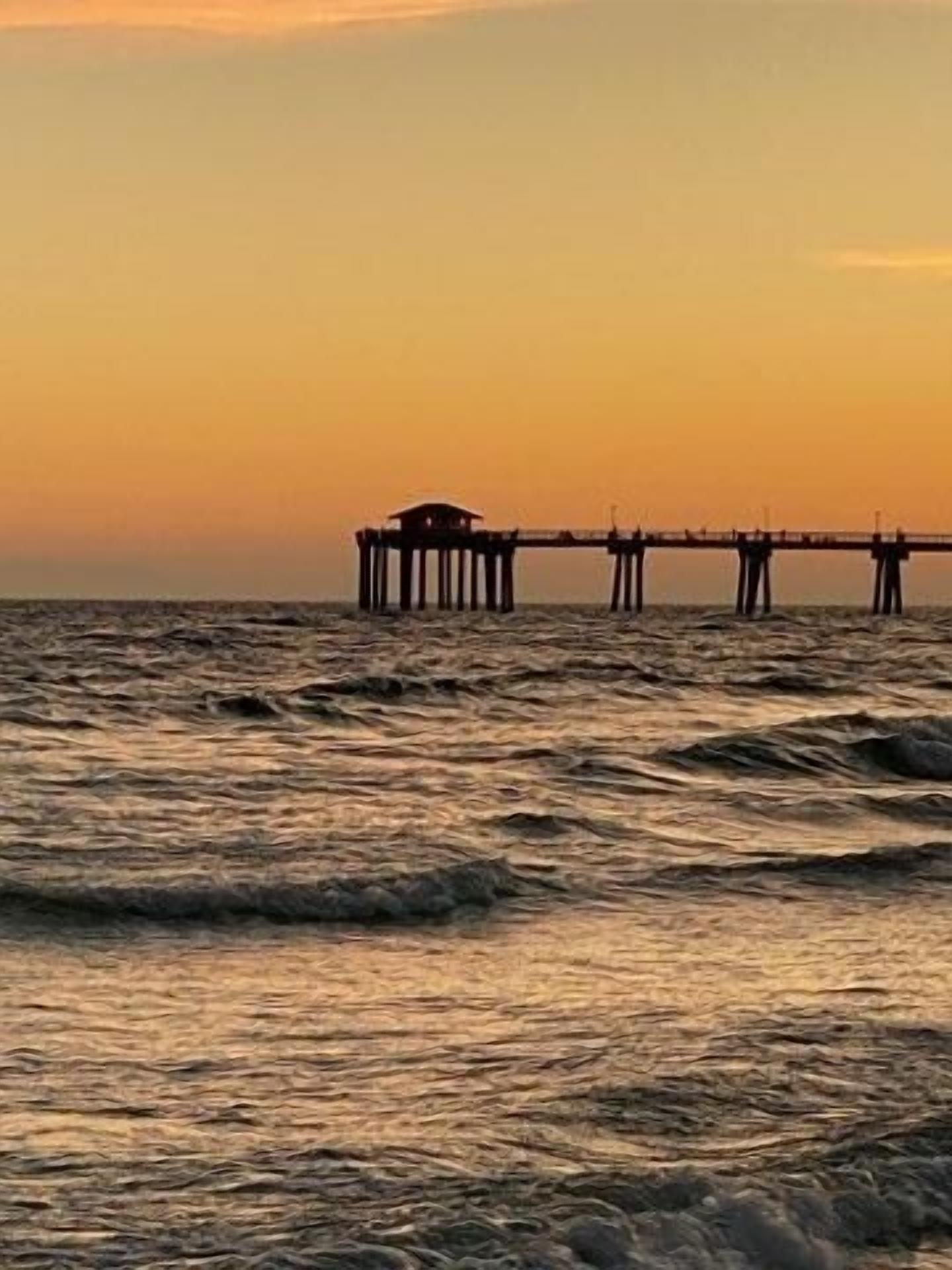 Un muelle que se adentra en el agua, con un edificio al final.