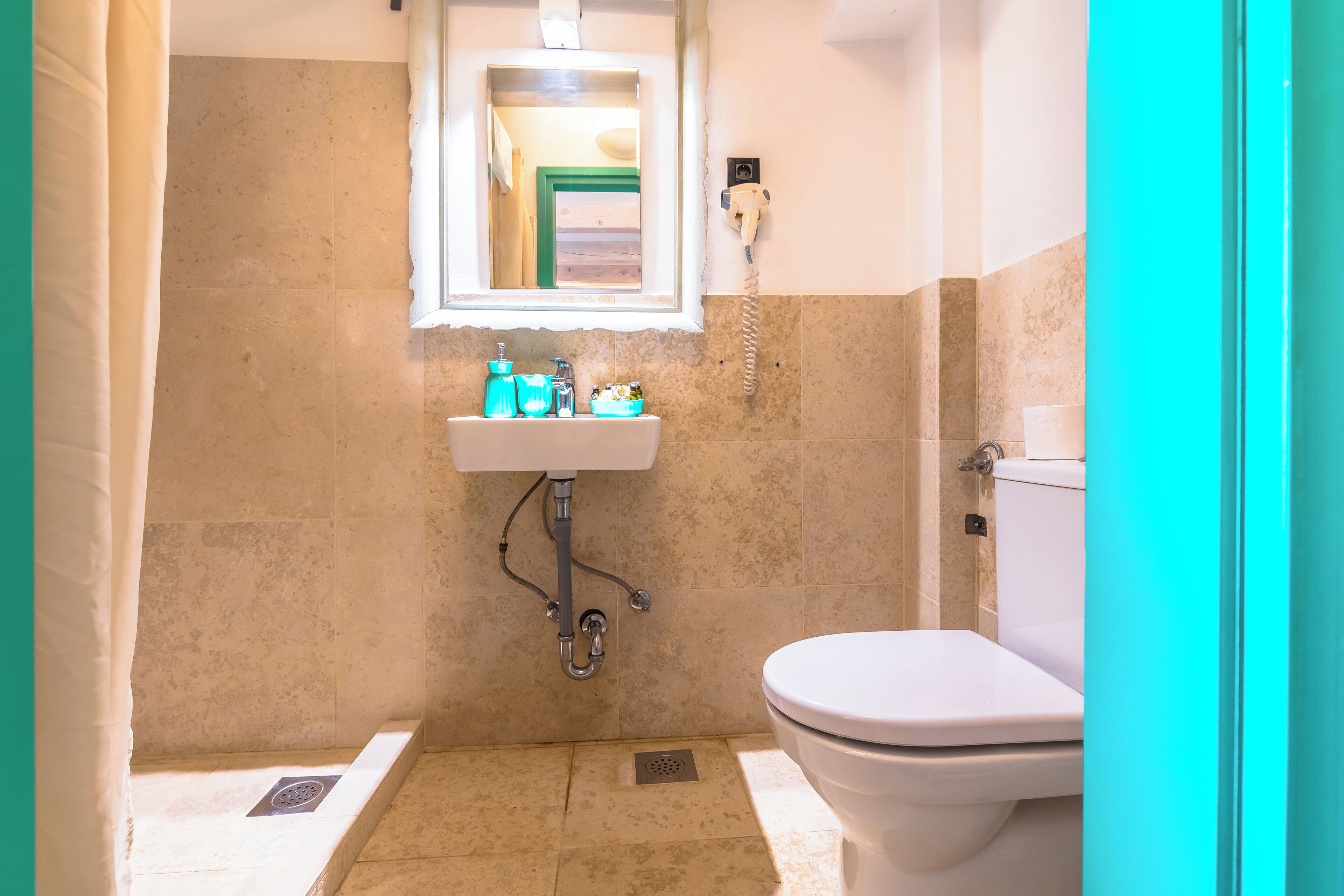 Un baño con inodoro, lavabo y zona de ducha.