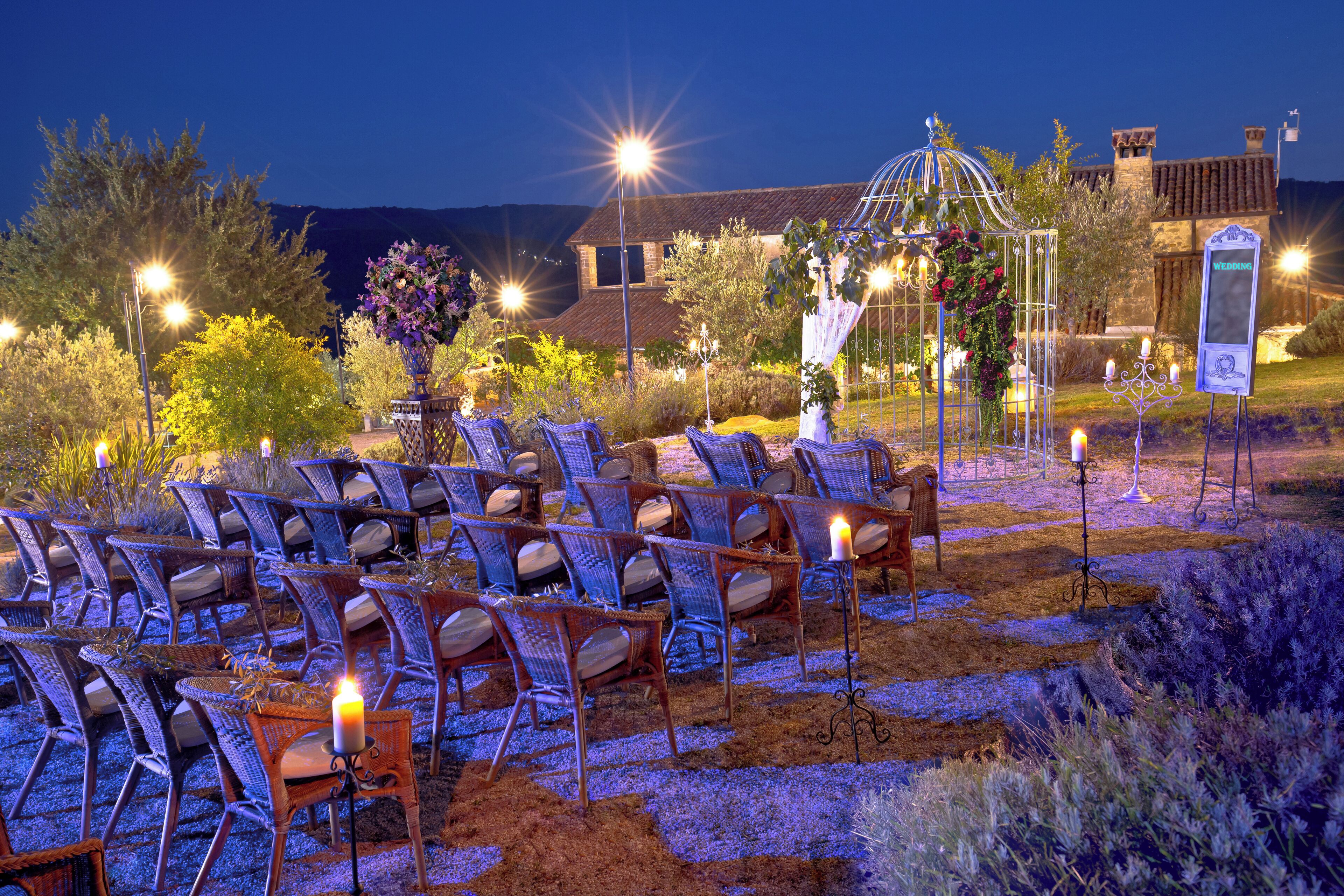 An outdoor seating area with chairs and tables, a gazebo, and a signboard.
