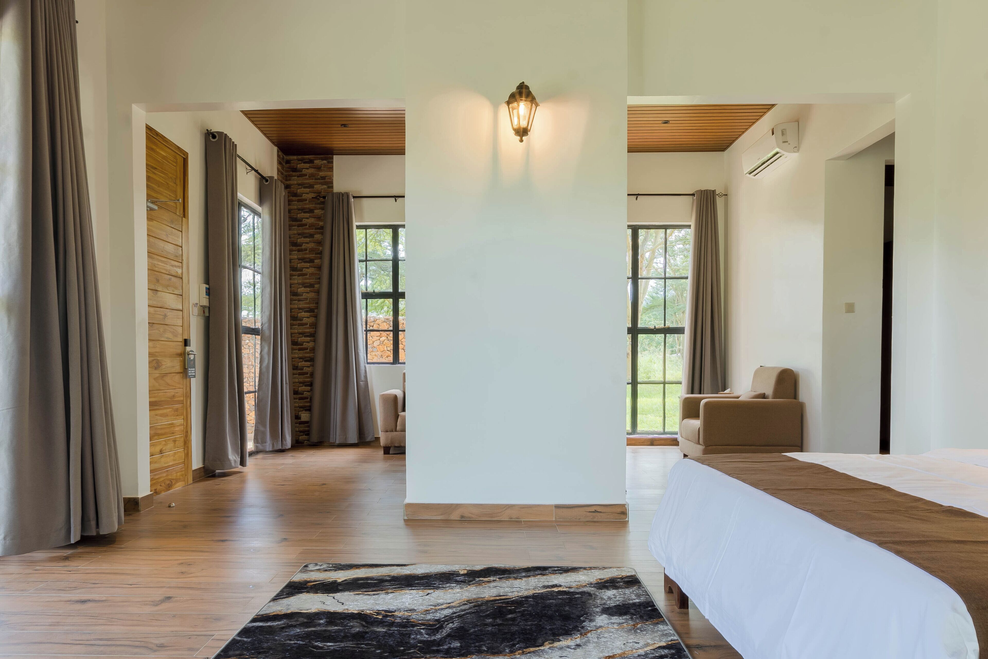 Un'ampia stanza con un letto grande, un muro in pietra e vista sull'esterno.