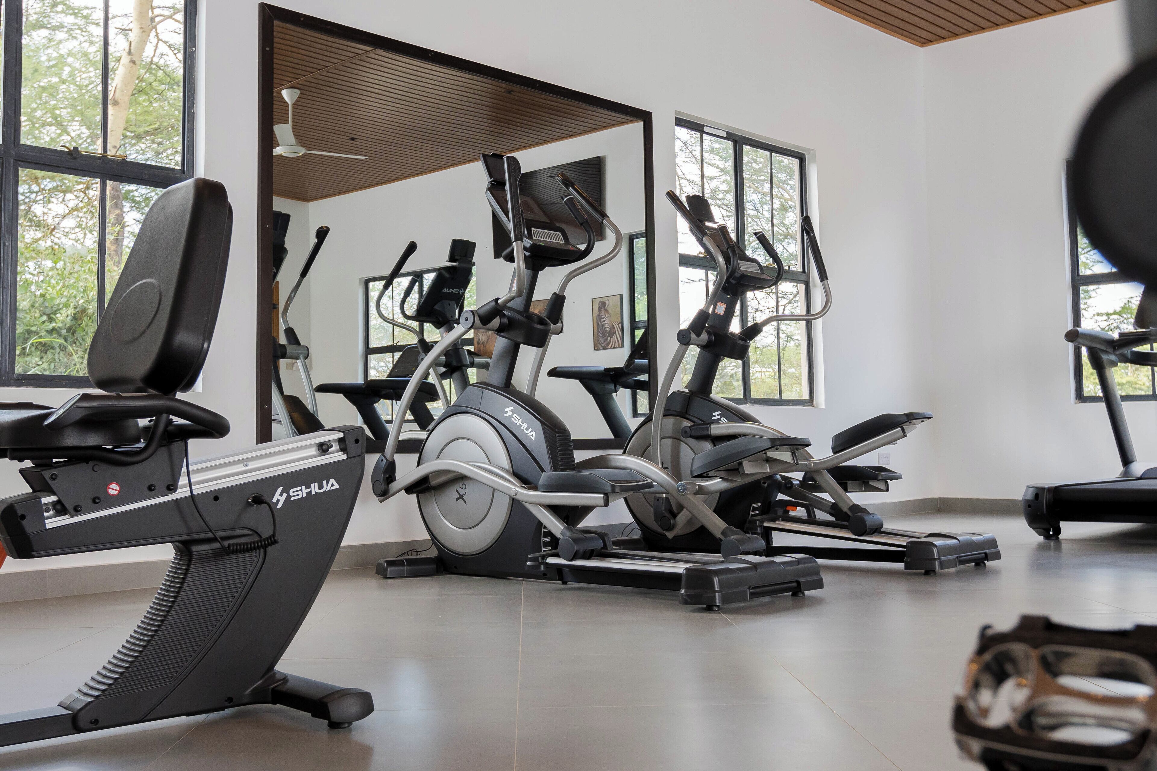 A gym with stationary bikes, elliptical machines, and a treadmill.