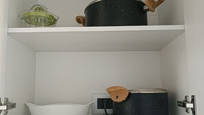 A kitchen cabinet with two shelves, each holding a pot and a bowl. - Kasa y Familia 811 (Valdivia)