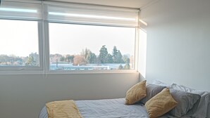 A bedroom with a bed, a window, and a ceiling light. - Kasa y Familia 811 (Valdivia)