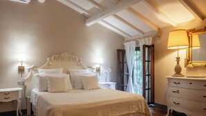 Een slaapkamer met een groot bed, twee nachtkastjes, een kaptafel en een spiegel.