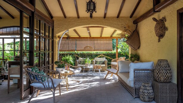 A covered patio with wicker furniture, a sofa, and decorative items. - Podere la Botte Pool Lari (Lari)