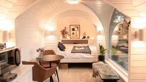 A cozy bedroom with a bed, bedside table, and a small seating area with a table and chairs. - Whole Coastal Estate · Sleeps 12 · Anglesey (Isle of Anglesey)