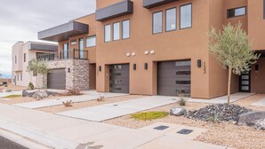 A modern multi-story building with a flat roof, large windows, and a stone facade. - Next to Pool, Sleek & Modern 3BR w/Fireplace (St. George)