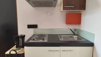 Kühlschrank, Herdplatte, Kochgeschirr/Geschirr/Besteck, Esstisch