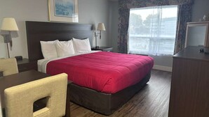 A hotel room with a large bed, two bedside tables, a desk, and a chair. - OceanShores Inn  (Ocean Shores)
