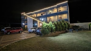 A multi-story hotel with a modern design, featuring a prominent overhang and illuminated exterior. - Hotel The Cult (Hubli)