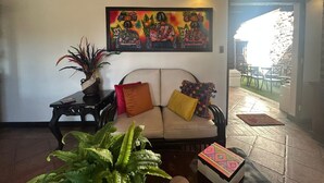 Un espacio de sala acogedor con un sofá, una mesa y un cuadro.