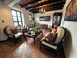 A spacious living room with a high ceiling, a chandelier, and a foosball table.