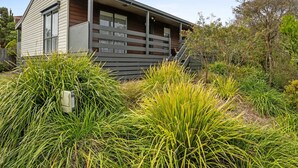 Uma casa moderna com um deck de madeira e varanda coberta.