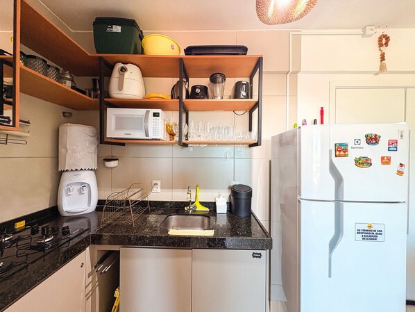 A compact kitchen with a microwave, kettle, and a refrigerator. - Açores Praia de Tamandaré - À Beira-Mar (Tamandaré)