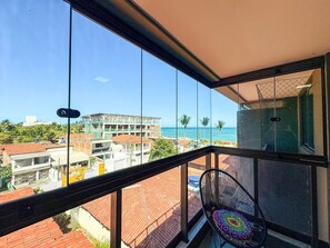 A balcony with a view of the sea, a chair, and a building under construction. - Açores Praia de Tamandaré - À Beira-Mar (Tamandaré)