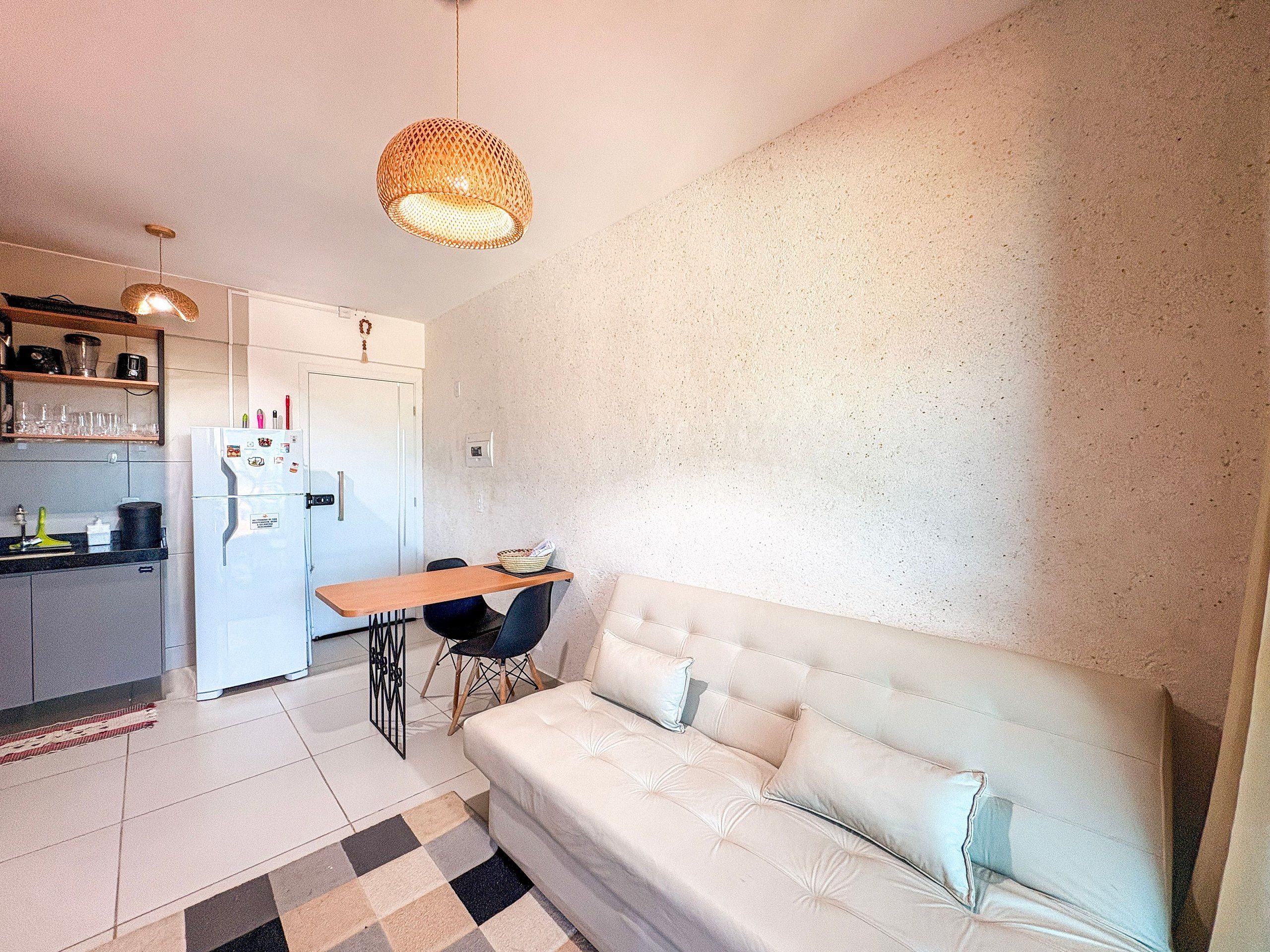 Un espace de vie compact comprenant un coin cuisine, un canapé et une table à manger.