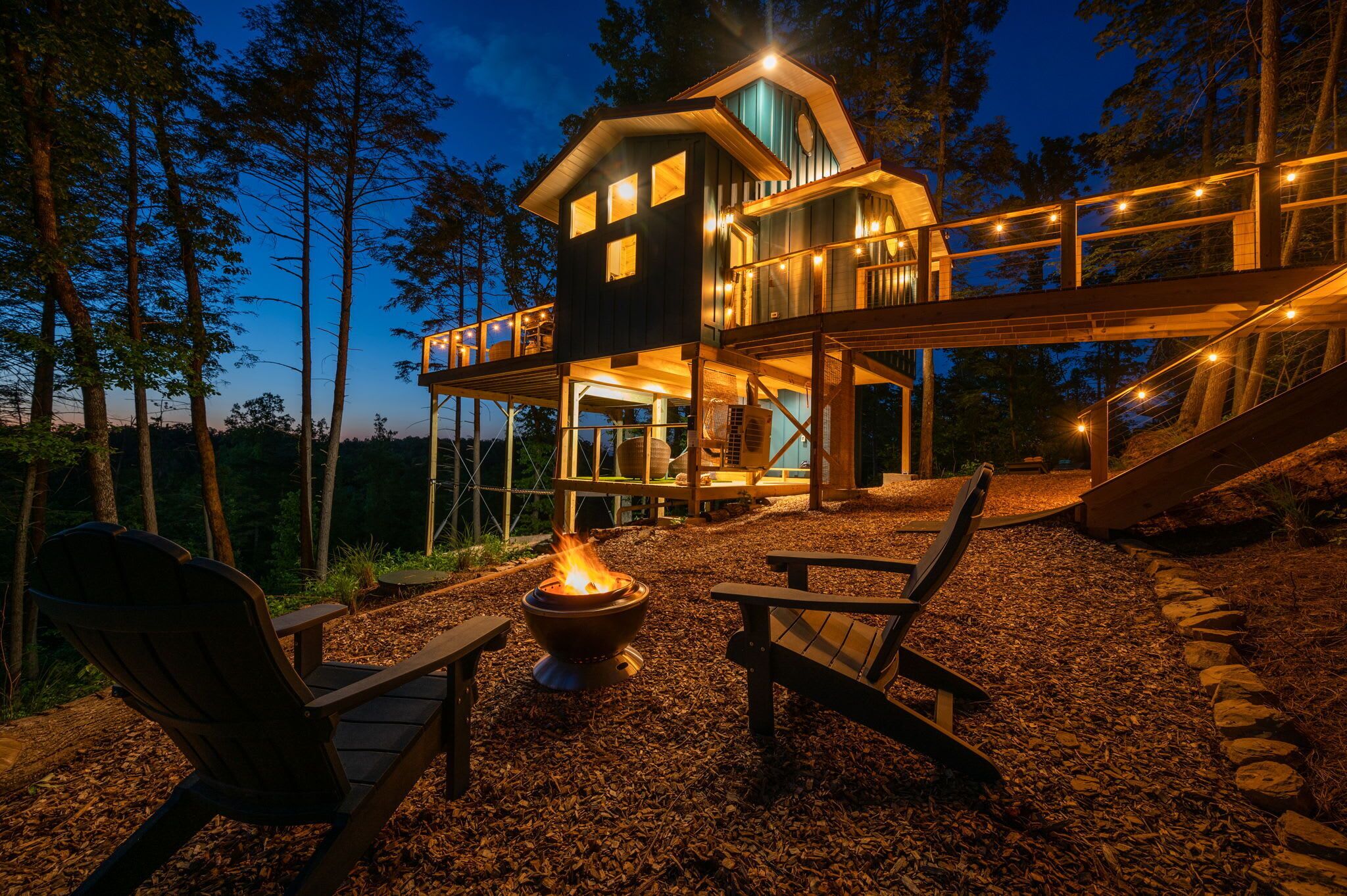 A cabin with a deck, a fire pit, and outdoor seating.