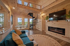 TV, fireplace - Romantic Forest Birdhouse • Hot Tub + Loft Net   |  A dreamy treetop escape with a slide, cozy reading nook, forest-view windows, and a fully stocked kitchen—perfect for couples looking for luxury, privacy, and peaceful woodland vibes. (Campton)