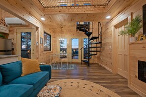 TV, fireplace - Romantic Forest Birdhouse • Hot Tub + Loft Net   |  A dreamy treetop escape with a slide, cozy reading nook, forest-view windows, and a fully stocked kitchen—perfect for couples looking for luxury, privacy, and peaceful woodland vibes. (Campton)