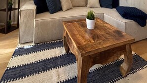 A living room with a sofa, a coffee table, a painting, and a hammock. - Apartment in 'Haus Anni' with Terrace and Wi-Fi (Bad Zwischenahn)