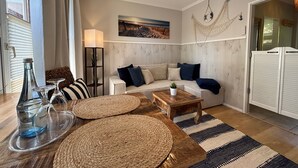 A living room with a sofa, coffee table, floor lamp, and a ceiling fan. - Apartment in 'Haus Anni' with Terrace and Wi-Fi (Bad Zwischenahn)