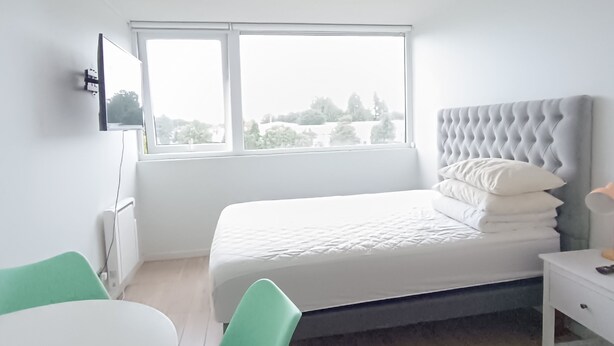 Une chambre à coucher moderne avec un lit, un bureau et une chaise.