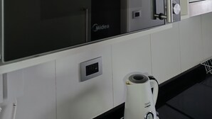 Une cuisine équipée d’un réfrigérateur encastré, d’une machine à café et d’une prise de courant.