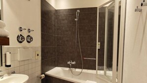 A bathroom with a bathtub, toilet, and sink. - Superior Studio for 3 in Konstanz (Konstanz)