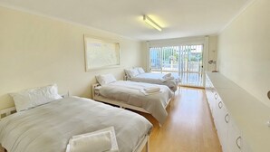 A hotel room with three beds, a large window, and a ceiling light. - Flipping Flounder - Coastal Comfort in Robe’s Heart (Robe)
