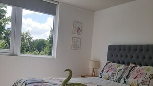 A bedroom with a bed, a window, and a nightstand with a lamp. - Kasa and family 220 (Valdivia)