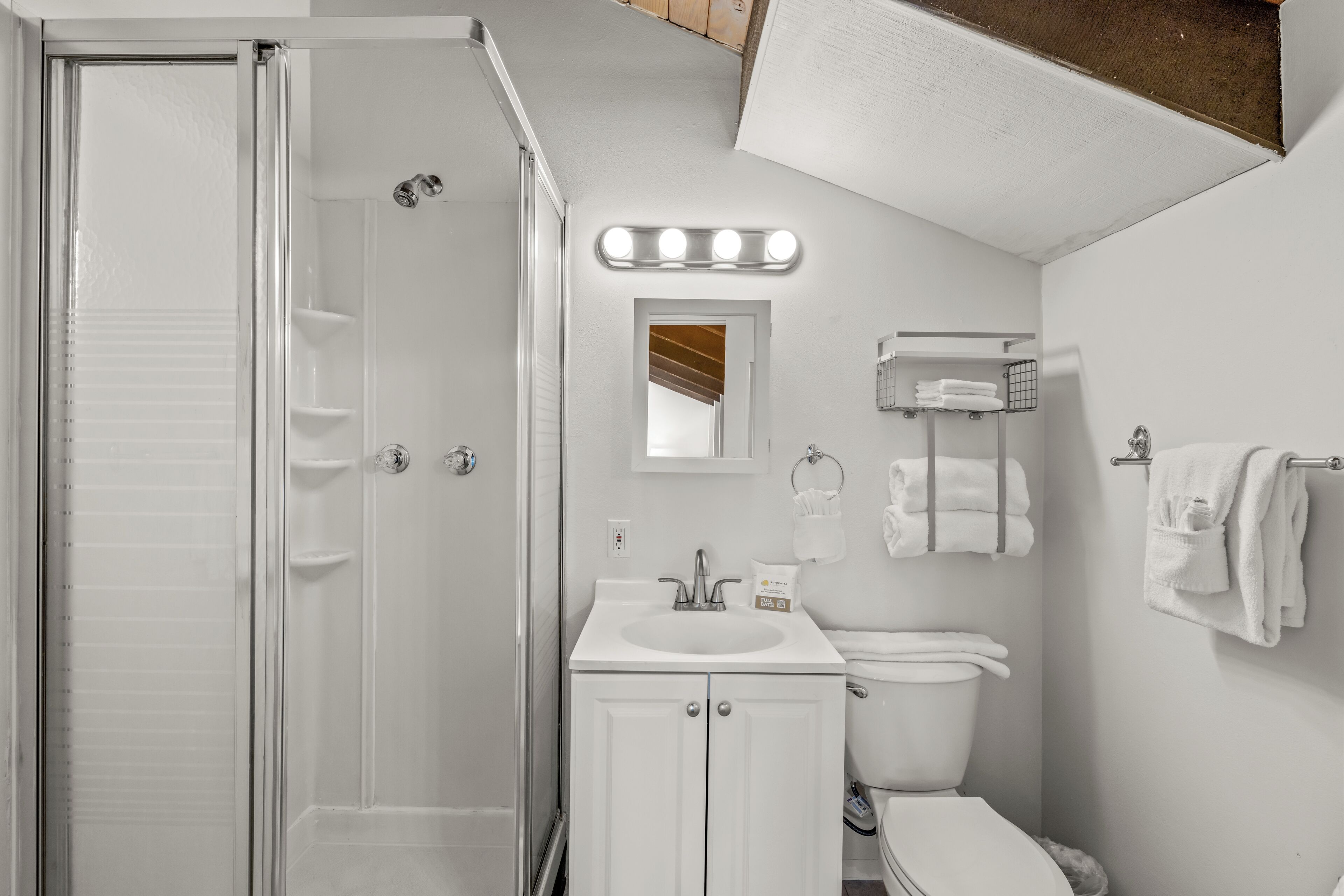 A bathroom with a shower, sink, toilet, and towel rack.