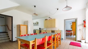 Une cuisine avec une table et des chaises, un escalier et un extincteur.