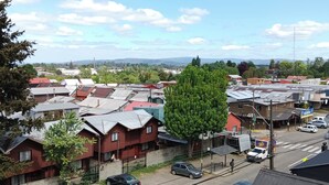 A residential area with houses, parked cars, and a clear sky. - Kasa and family 522 (Valdivia)