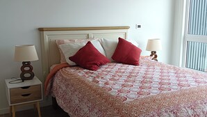 A bedroom with a bed, two bedside tables, and a window. - Kasa and family 522 (Valdivia)