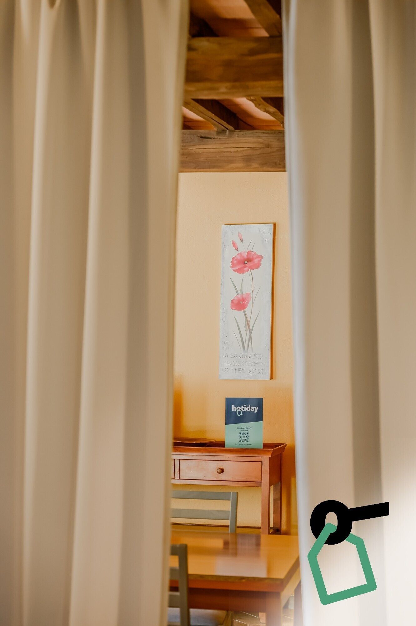 A room with a wooden desk, a framed artwork on the wall, and a sign indicating a holiday rate.