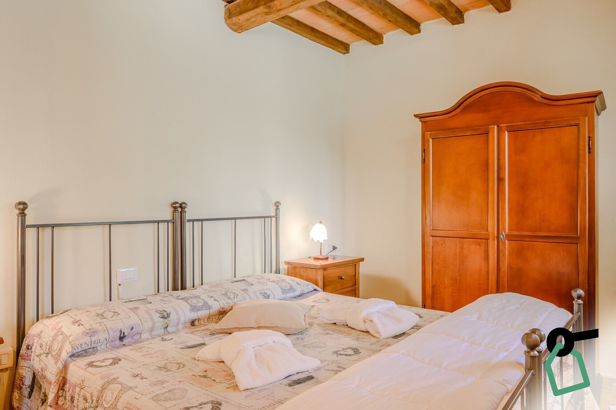 Une chambre à coucher avec un lit, une table de chevet, une lampe et une armoire.