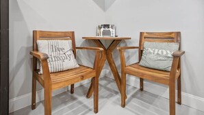 Two wooden chairs with cushions, a small wooden table, and a white wall with a vent. - Raven Feather Retreat : Unit 2 (Liberty Township)