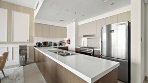 Una cucina moderna con una grande isola, elettrodomestici in acciaio inossidabile e forno integrato.