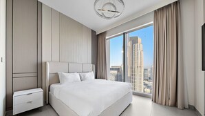 Una camera da letto moderna con un letto grande, un comodino, una televisione e vista sulla città.