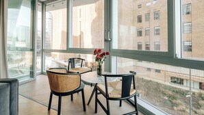 Una habitación moderna con ventanas amplias, una mesa redonda y dos sillas.
