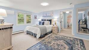 A bedroom with a bed, bedside tables, a nightstand, a dresser, a window, and a door leading to another room. - Game Room, Central AC, 4 mins to Craigville Beach! (Barnstable)