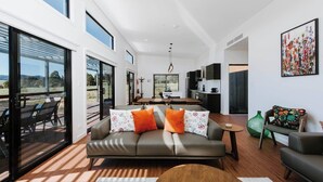 En moderne stue med sofa, spisebord og et køkkenområde.